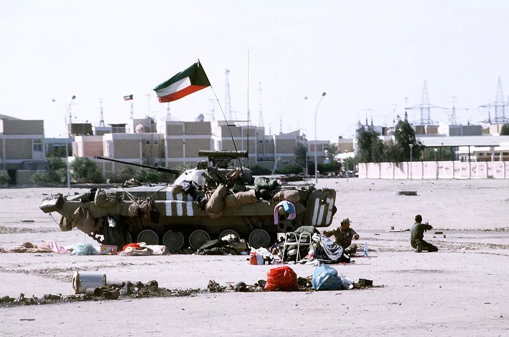 Kuwaiti soldiers sit beside a Kuwaiti BMP-2 infantry fighting during Operation Desert Storm