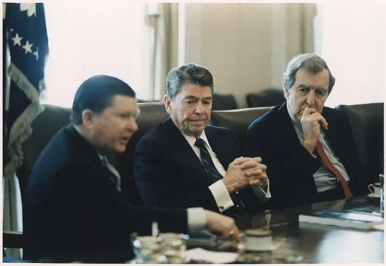 President Reagan, center, receiving the Tower Commission Report in the Cabinet Room. To the left is Senator John Tower and to the right is Senator Edmund Muskie 26 February 1987