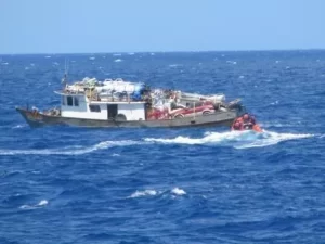 A small boat crew from the Coast Guard Cutter Key Biscayne assists people aboard a 65-foot Haitian-flagged vessel in distress on June 1 about 65 miles north of Haiti.