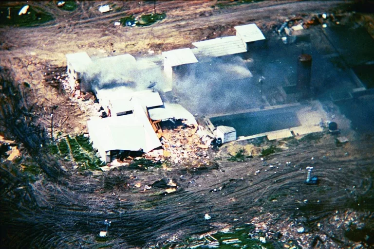 Smoke from Waco Branch Davidian fire second floor bedroom increases and spreads across back of building. 19 April 1993