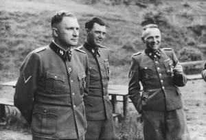 Auschwitz, Poland 1944 Three SS officers socialize on the grounds of the SS retreat outside of Auschwitz, at “Solahütte”, 1944. From left to right they are: Richard Baer (Commandant of Auschwitz), Dr. Josef Mengele and Rudolf Hoess