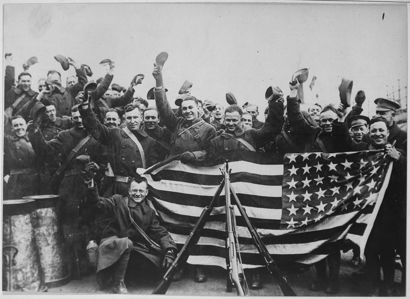 American troops in Russian port about to leave that country. They are here cheering and displaying the stars and stripes as the tender was coming for them. Central News Photo Service, ca. 1919 - ca. 1920