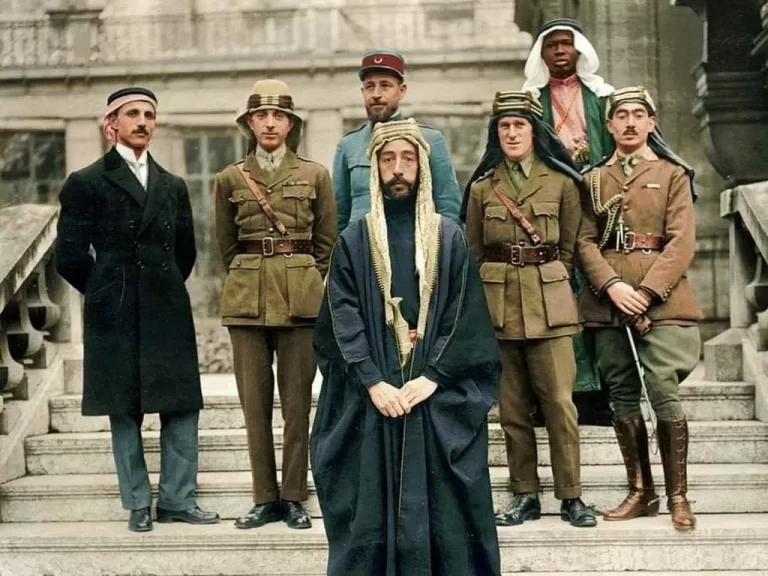 Emir Faysal I at Versailles Conference. Left to right: Rustum Haidar, Nuri as-Said, Prince Faisal (front), Captain Rosario Pisani(rear), T. E. Lawrence, Faisal's slave (name unknown), Captain Hassan Khadri.