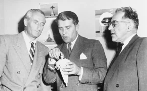 Dr. Wernher von Braun (center), then Chief of the Guided Missile Development Division at Redstone Arsenal, Alabama, discusses a "bottle suit" model with Dr. Heinz Haber (left), an expert on aviation medicine, and Willy Ley, a science writer on rocketry and space exploration.