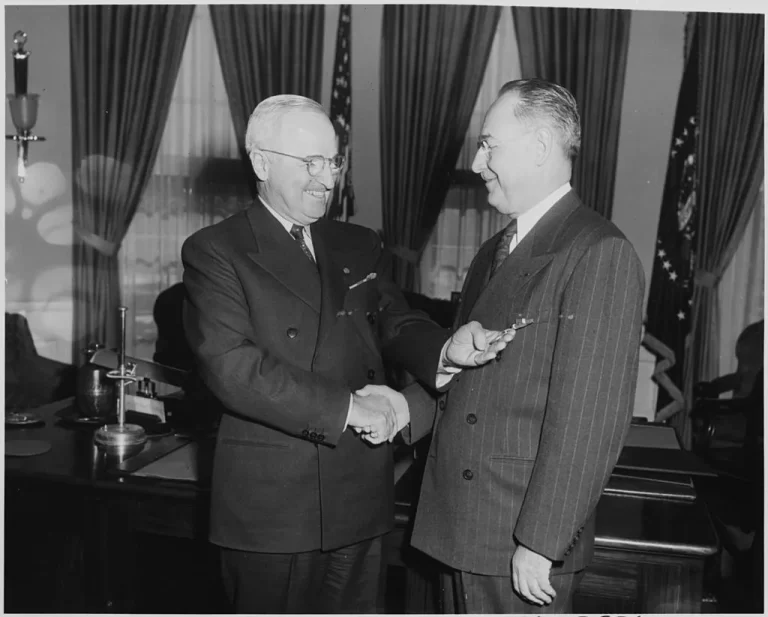 Photograph of President Truman in the Oval Office presenting the Distinguished Service Medal to Rear Admiral Sidney Souers, U.S. Naval Reserve, for a meritorious career in government that included service as the first Director of Central Intelligence (1946) and the first Executive Secretary of the National Security Council