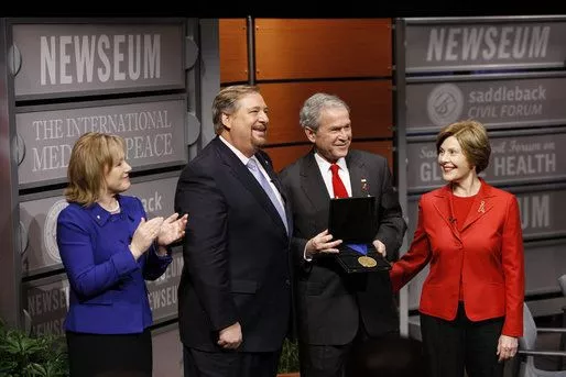 President George W. Bush, joined by Mrs. Laura Bush, is presented with the International Medal of PEACE by Pastor Rick Warren and his wife, Kay Warren, left, Monday, Dec. 1, 2008, following their participation at the Saddleback Civil Forum on Global Health in Washington, D.C.