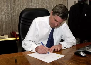 Ambassador L. Paul Bremer signs the Iraqi Sovereignty document in his office at the Coalition Provisional Authority Headquarters in Baghdad, Iraq, transferring full governmental authority to the Iraqi Interim Government June 28, 2004