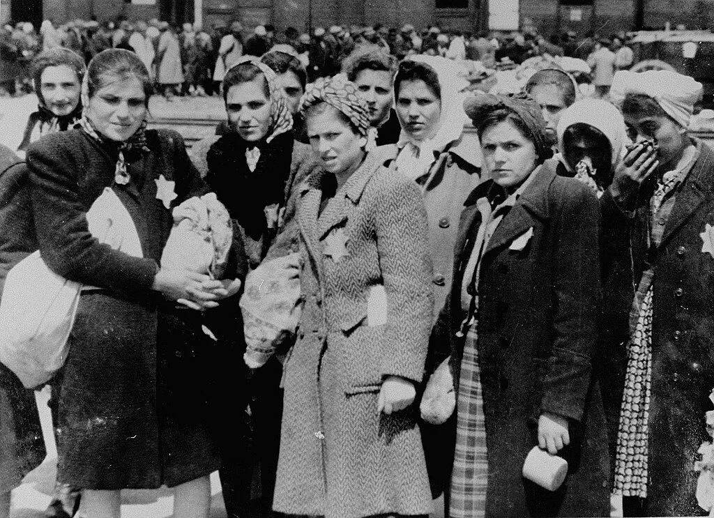 Jewish women from Subcarpathian Rus who have been selected for forced labor at Auschwitz-Birkenau, wait to be taken to another section of the camp.