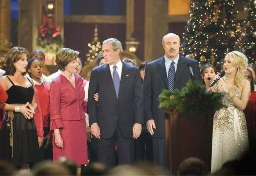 Dr. Phil McGraw, his wife Robin, left, and Carrie Underwood, right, alongside President and Mrs. Bush sing "Hark, the Herald Angels Sing!" during the 24th Annual Christmas in Washington DC